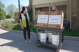 Hyang Cho and Chad Callander in front of Meals on Wheels London
